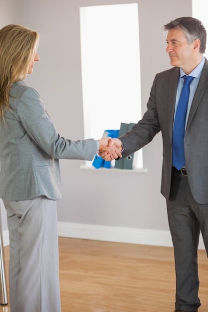 Two business people shaking hands over a contract with a pen, implying a successful negotiation and agreement on terms with a digital marketing agency.