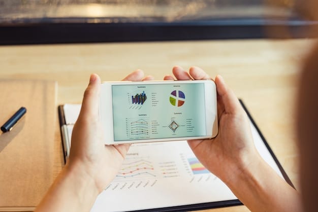 A person's hand holding a smartphone displaying market research data and competitor analysis on the screen, with a laptop in the background showing a spreadsheet of ideas, symbolizing strategic planning.