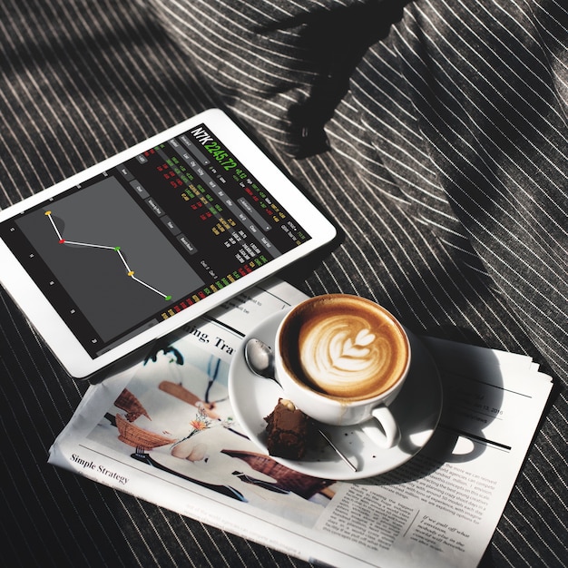 A detailed financial dashboard on a tablet screen, showing various charts and numbers related to investments and financial growth, with a cup of coffee nearby.